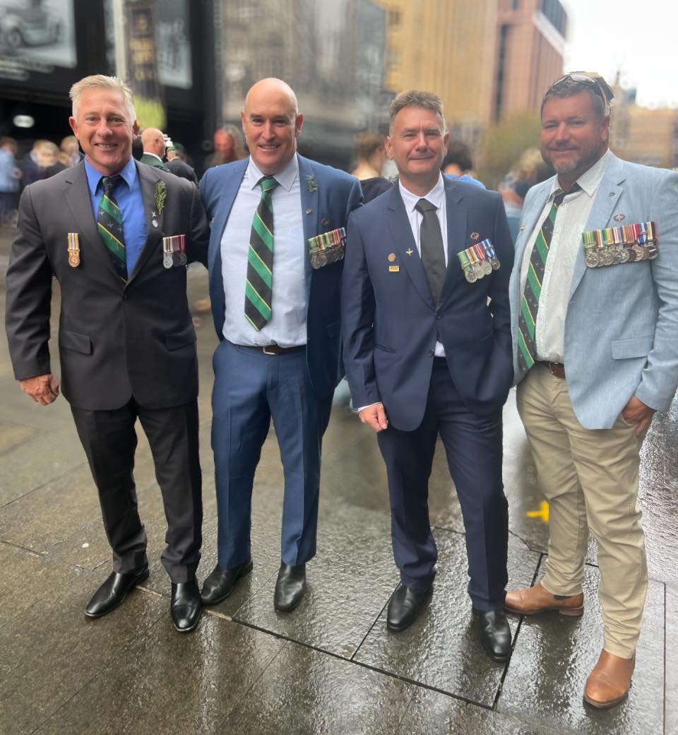 Will Collett with three fellow veterans in suits and service medals on Anzac Day